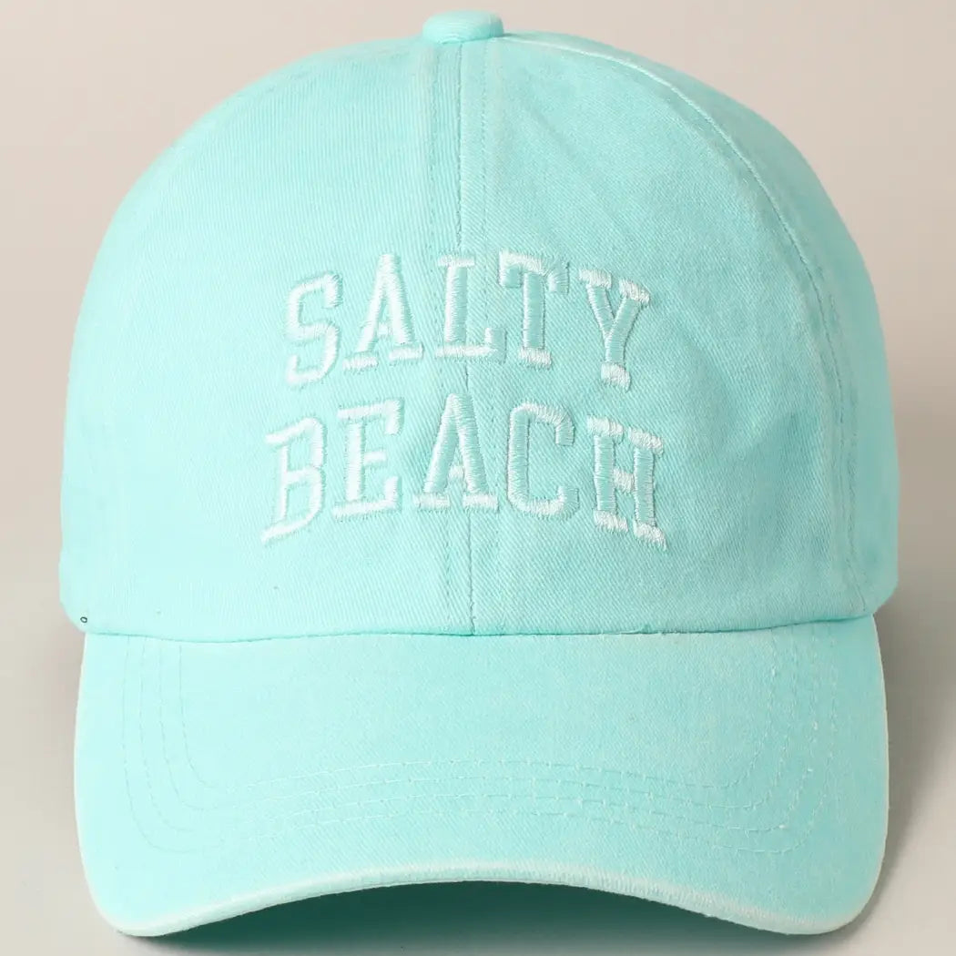 Light mint green cap with 'Salty Beach' text on a beige background